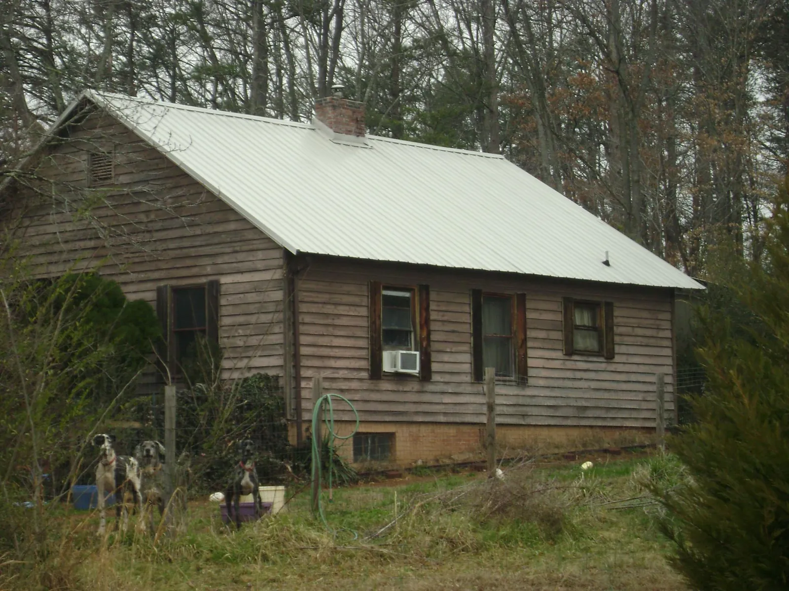 White metal roof on an old wood sided farmhouse, from a Metal Roof Installation job in Fairfax